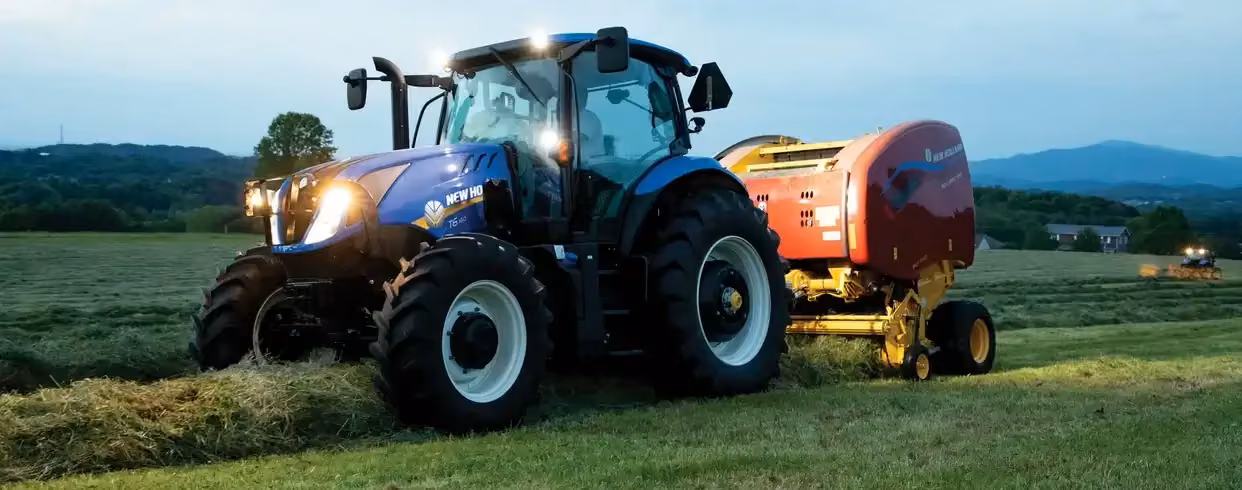 New Holland T6 tractor baling at dusk