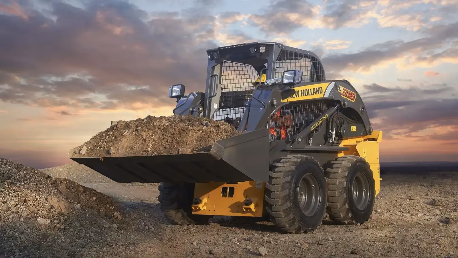 New Holland skid steer loader with a loaded bucket at dusk