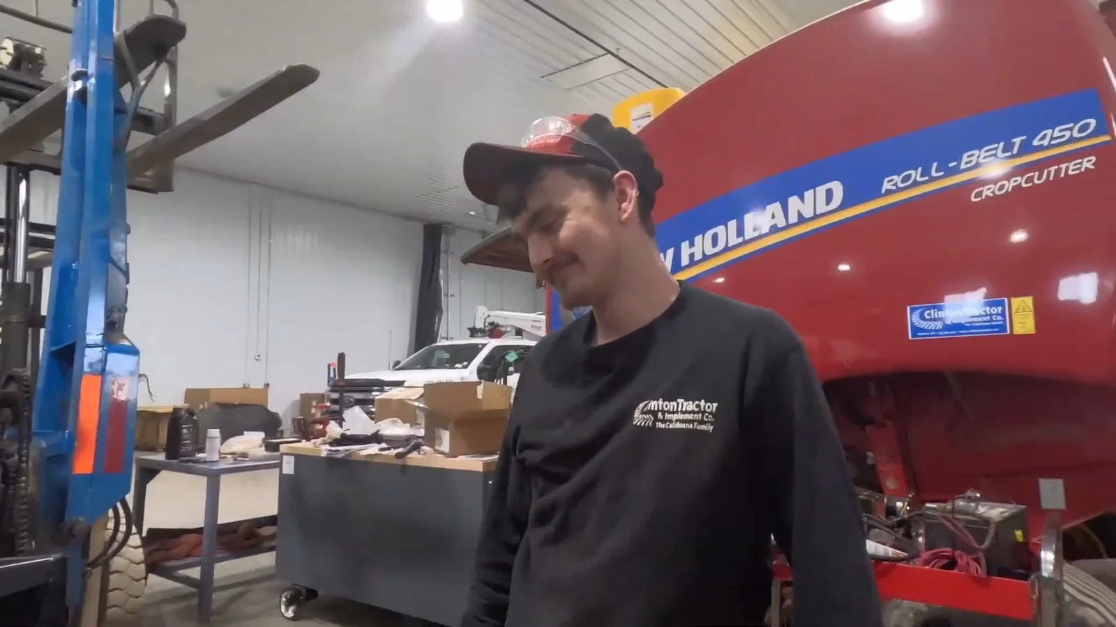 A technician working on a New Holland round baler